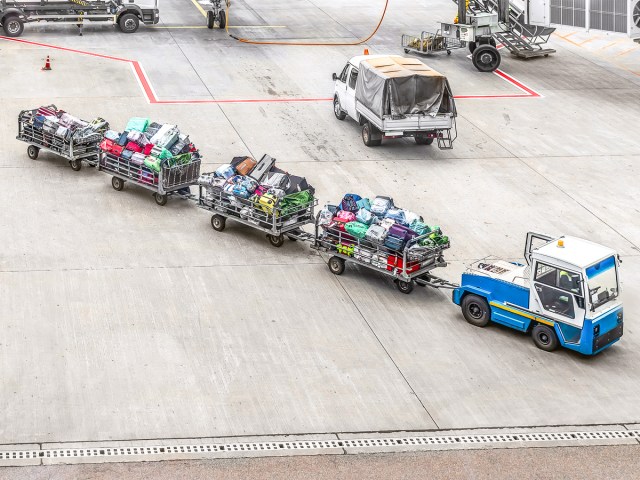 Baggage carts being towed to aircraft