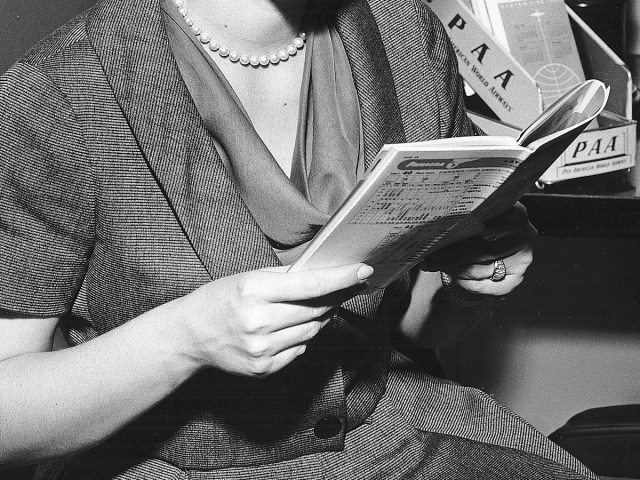 Vintage photo of airline passenger perusing timetable