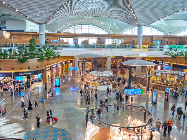 Passengers walking through airy terminal of Istanbul Airport in Turkey