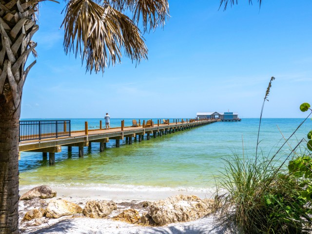 Person walking down pier from Anna Maria Island