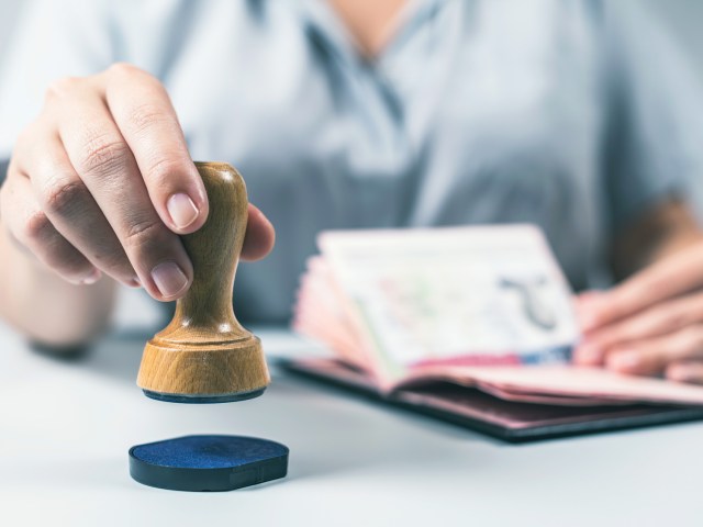 Immigration official stamping passport at airport