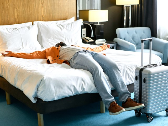 Traveler lying on hotel bed