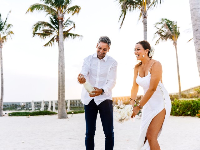 Couple celebrating on beach at Hilton Tulum Riviera Maya All-Inclusive Resort