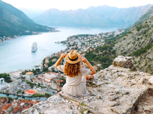 Traveler admiring landscape of coastal European city from lookout