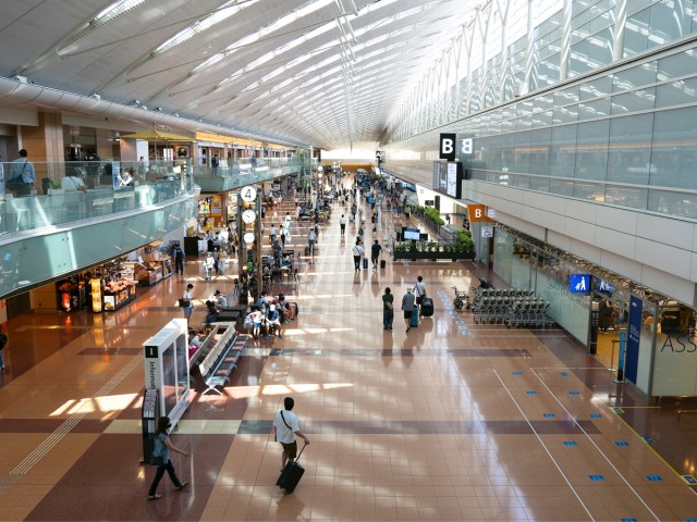 Passengers walking through terminal at Tokyo Haneda Airport