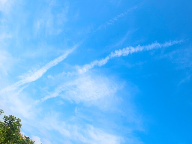 Remnants of airplane contrails in clear blue sky