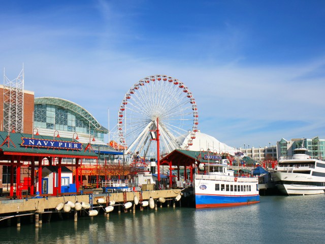 Boats docked along Navy Pier, with Ferris wheel towering above