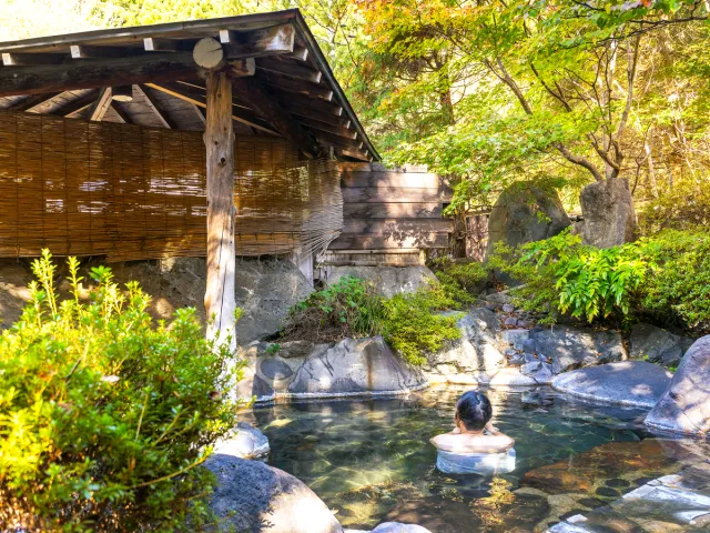 Guest bathing in onsen at traditional Japanese ryokan