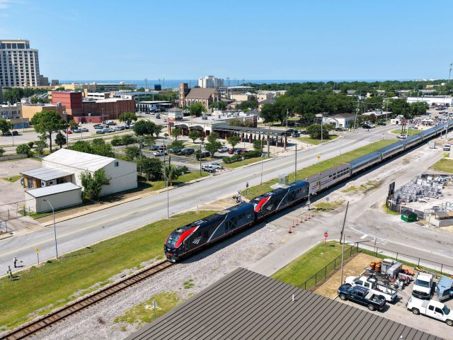 Aerial view of Amtrak train traveling through city