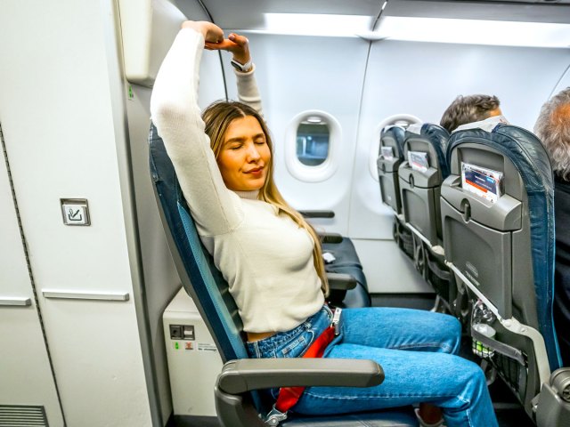 Airline passenger stretching in seat