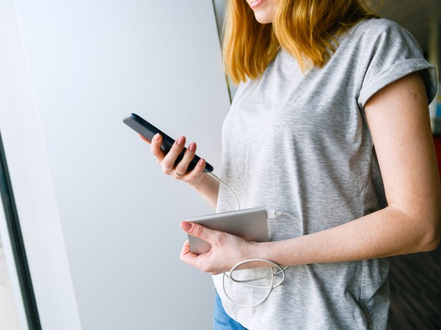 Person using portable charger to power cellphone