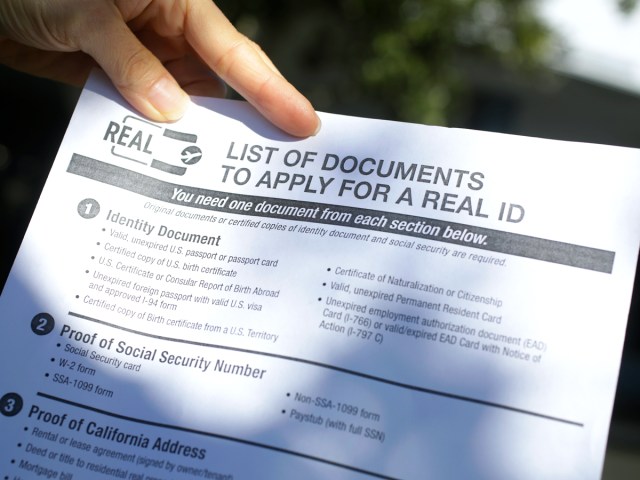 Person holding document outlining requirements to apply for REAL ID