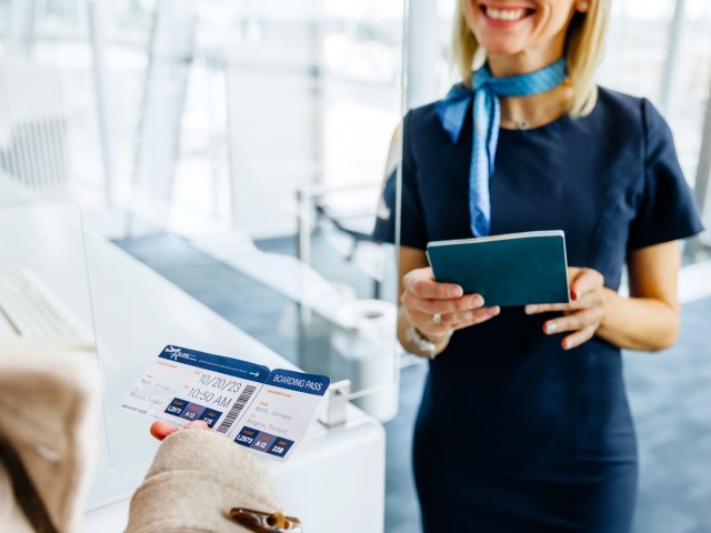Airport employee checking passenger's travel documents