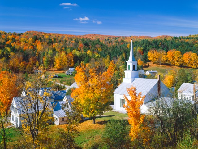 Aerial view of fall foliage surrounding church in Vermont