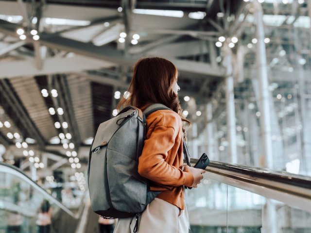 Traveler with backpack on escalator in airport
