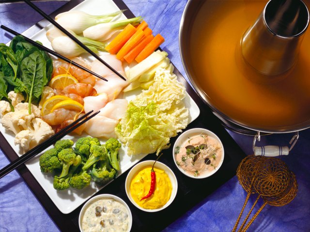 Fondue pot with ingredients on table