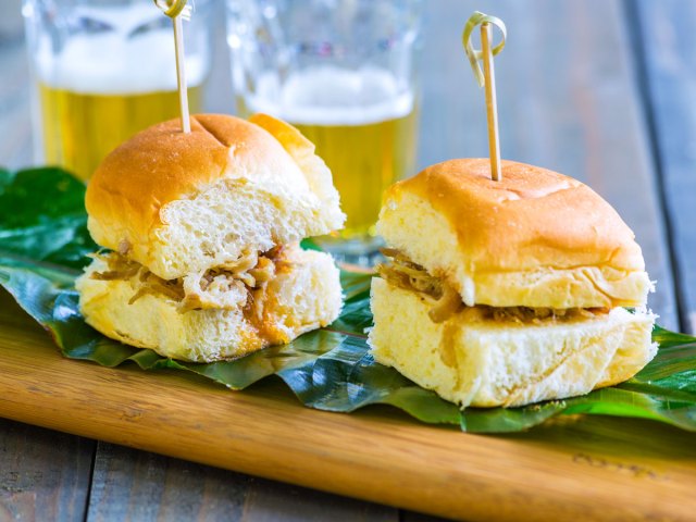 A Kālua pork sandwich on a cutting board