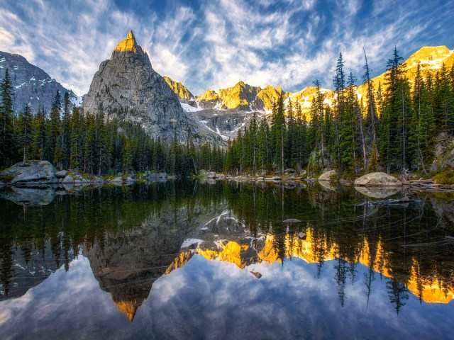 Reflection of clouds, trees, and mountain peaks on Mirror Lake