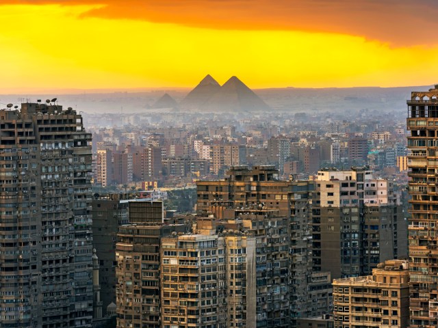 Pyramids of Giza seen beyond Cairo skyline at sunset