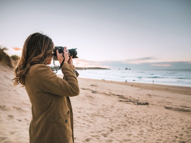 Woman taking photograph on beach