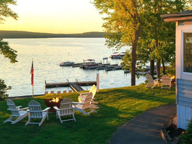 Chairs around fire pit overlooking docks on lake in the Poconos at sunset
