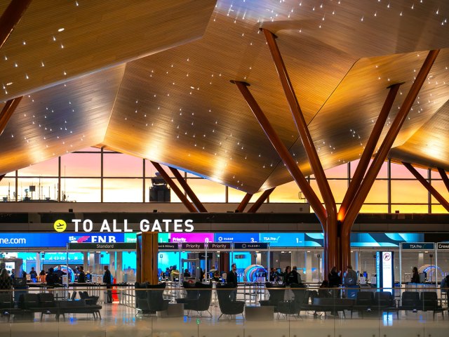 Sign toward all gates under undulating wood ceilings at the new Pittsburgh International Airport