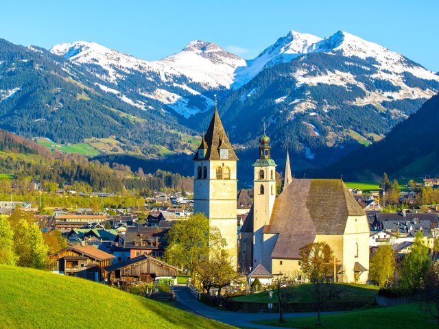 Church surrounded by mountains in town of Kitzbühel, Austria