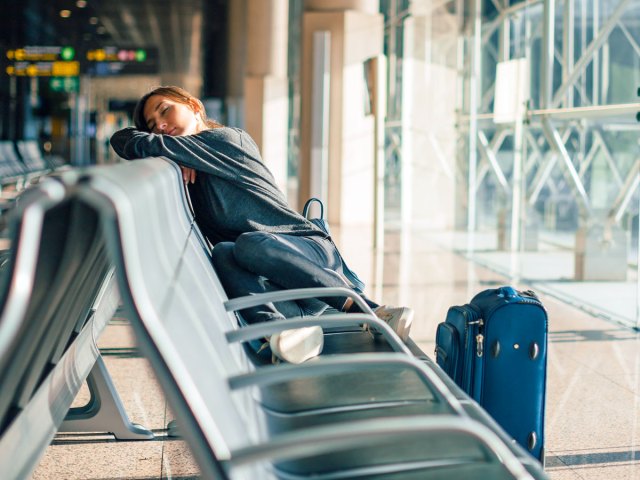 Traveler resting at airport gate seating
