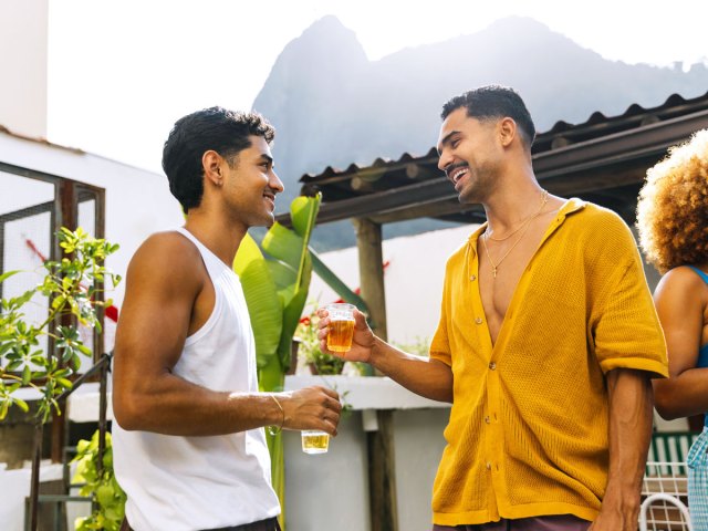 Two people conversing with drinks in hand