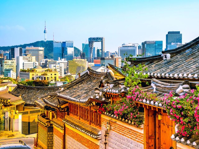 Traditional houses with modern skyscrapers of Seoul in distance