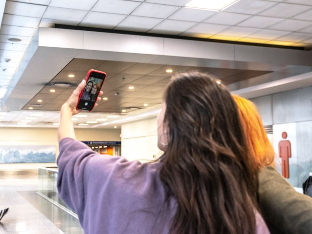 Travelers taking selfie in airport terminal
