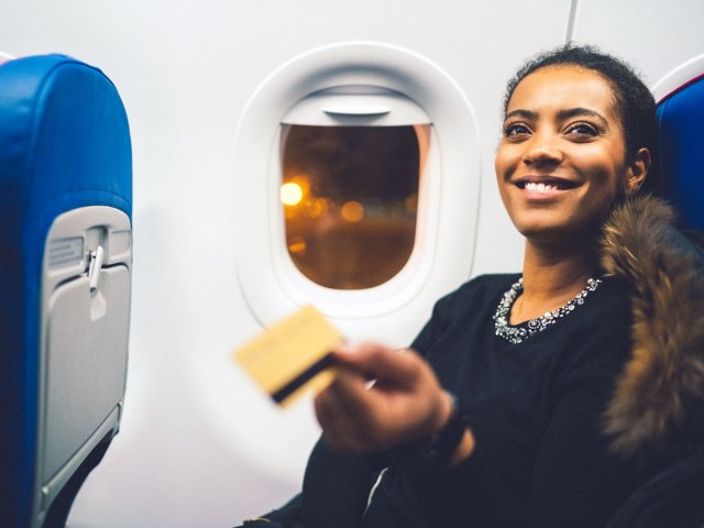 Passenger handing over credit card for payment on airplane