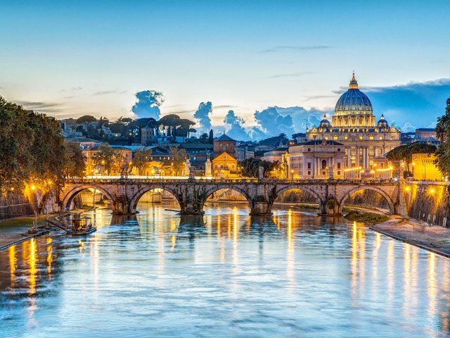 Bridge over the Tiber River with view of St. Peter's Basilica at dusk