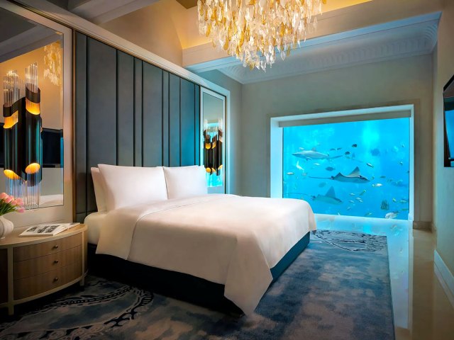 Underwater suite at Atlantis Dubai with bed overlooking marine life