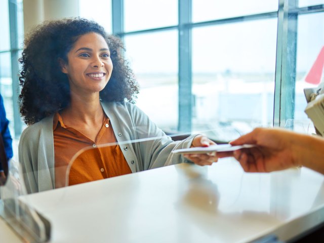 Airline passenger handing over travel documents to agent