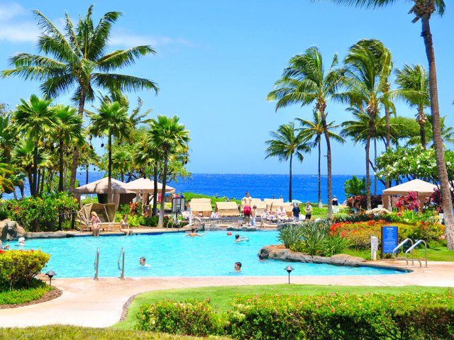 Hotel pool with ocean in background in Hawaii