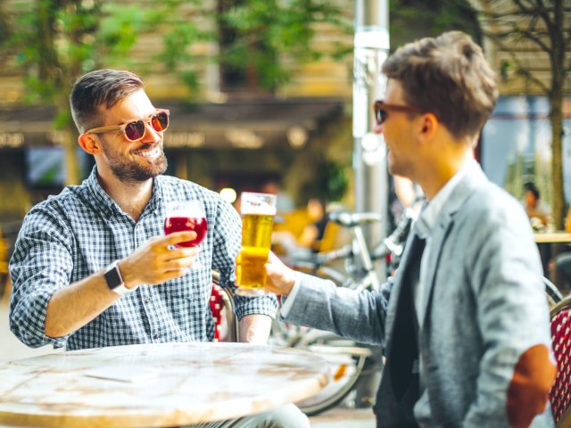 Two men drinking beer on patio