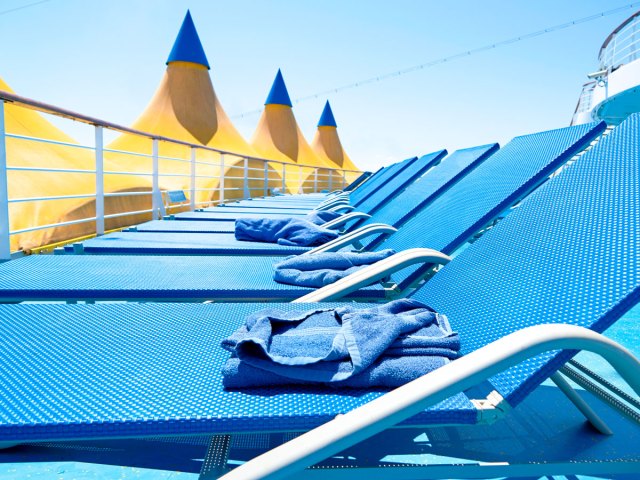 Lounge chairs with towels on pool deck