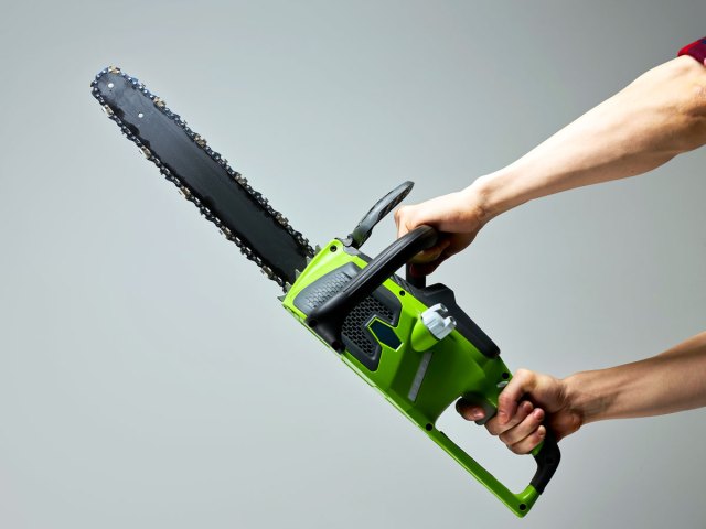 Person holding chainsaw