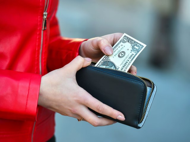 Person taking $1 bill out of wallet