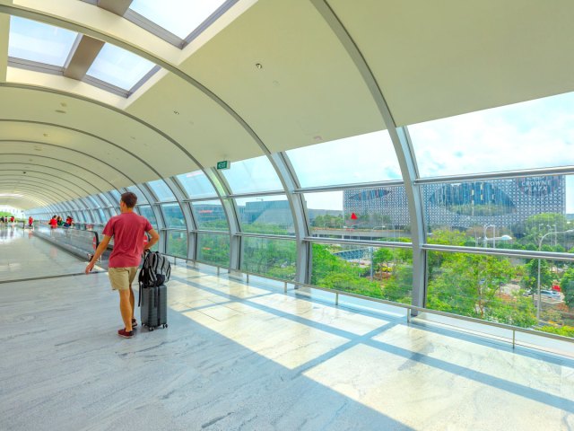 Walkway at Singapore Changi Airport with view of Crowne Plaza hotel in distance